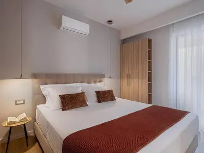 a bedroom with a large white bed and a window at Angelo Luxury Apartment in Chania Town