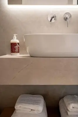 a bathroom with a sink and a shelf with towels at Angelo Luxury Apartment in Chania Town
