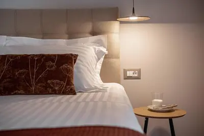 a bed with a pillow and a table with a candle at Angelo Luxury Apartment in Chania Town