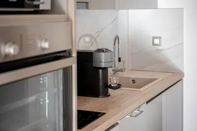 a kitchen counter with a coffee maker and a sink at Angelo Luxury Apartment in Chania Town