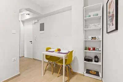 a dining room with a white table and yellow chairs at Nisos apartments, Chania center in Chania Town