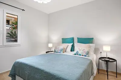 a bedroom with a bed with blue and white pillows at Nisos apartments, Chania center in Chania Town