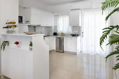 a white kitchen with white cabinets and a large window at -Superior Maisonette Jacuzzi & Private Parking - Koum Kapi Mare Seaside in Chania Town