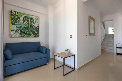 a living room with a blue couch and a table at -Superior Maisonette Jacuzzi & Private Parking - Koum Kapi Mare Seaside in Chania Town
