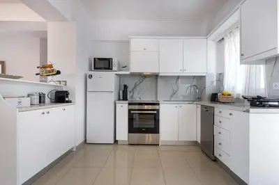a white kitchen with white cabinets and appliances at -Superior Maisonette Jacuzzi & Private Parking - Koum Kapi Mare Seaside in Chania Town