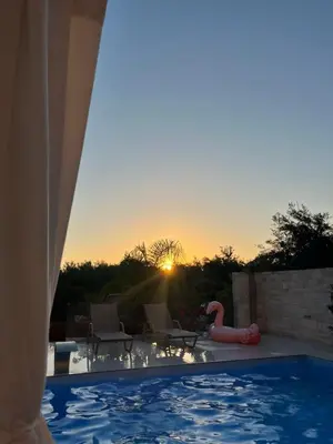 a swimming pool with a flamingo in the sunset at Amare suite in Perivólia
