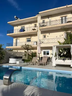 a hotel with a swimming pool in front of a building at Amare suite in Perivólia