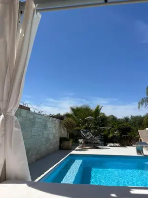 a view of a swimming pool through a window at Amare suite in Perivólia