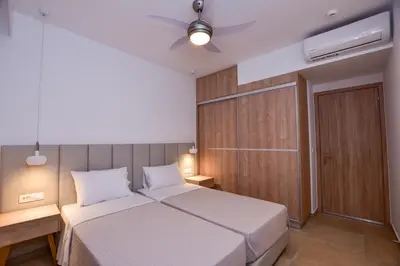 a bedroom with a bed and a ceiling fan at Rosemary Apartments in Palaiochóra