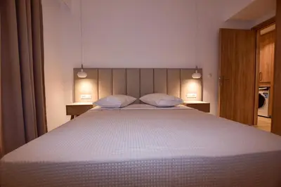 a bedroom with a large white bed with two pillows at Rosemary Apartments in Palaiochóra