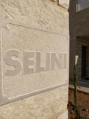 a stone sign for a se firm on a building at Christos Place-Paleochora in Palaiochóra