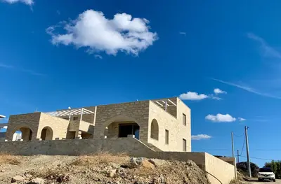 a building on top of a hill with a blue sky at Christos Place-Paleochora in Palaiochóra
