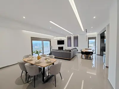 a living room with a table and chairs and a couch at Christine luxury villa in Kolymvari