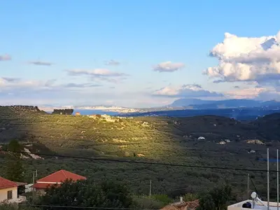 a view of a green hill with the ocean in the background at Christine luxury villa in Kolymvari