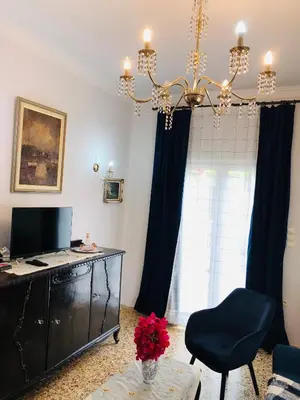 a living room with a desk and a chandelier at Stamatias Home, fully equipped cottage 5 minutes from the sea in Chania Town