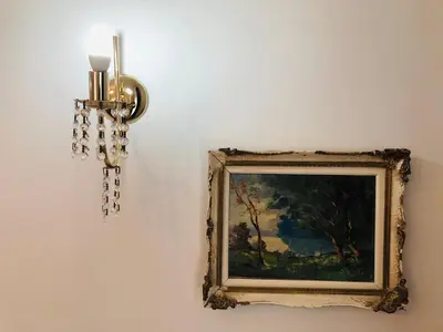 a picture on a wall with a chandelier and a painting at Stamatias Home, fully equipped cottage 5 minutes from the sea in Chania Town