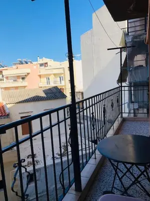 a balcony of a building with a table and a table gmaxwell gmaxwell gmaxwell at Ariadni's apartment 2 in Chania Town