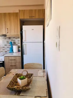 a kitchen with a table and a white refrigerator at Ariadni's apartment 2 in Chania Town