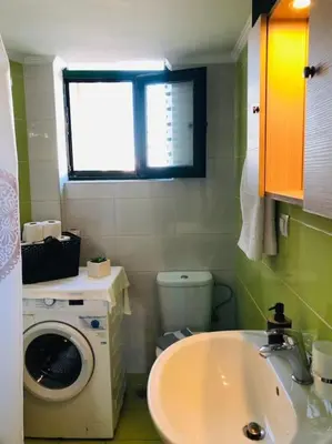 a bathroom with a washing machine and a sink at Ariadni's apartment 2 in Chania Town