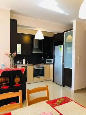 a kitchen with a refrigerator and a table with chairs at Ariadni's apartment 1 in Chania Town