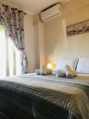 a bedroom with a bed with white pillows and a window at Ariadni's apartment 1 in Chania Town