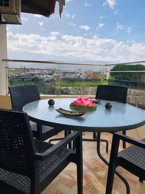 a blue table with chairs and a pink flower on it at Ariadni's apartment 1 in Chania Town