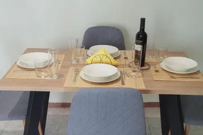 a wooden table with plates and a bottle of wine at Capt73134 in Chania Town