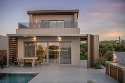 a house with a patio and a dining area at Fivi Villa, with Heated Pool & SeaViews, By ThinkVilla in Tavronitis