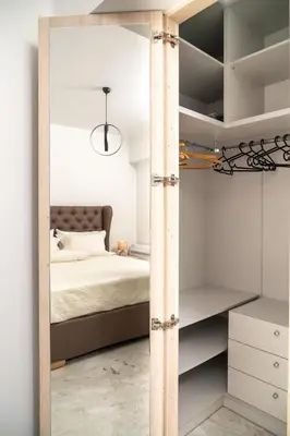 a bedroom with a bed and a mirror at EDEL Luxury Apartments in Chania Town