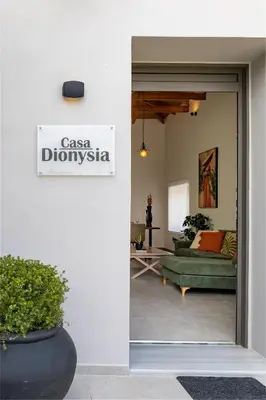 a living room with a green couch and a sign at Casa Dionysia - New Lux 2Br with Jacuzzi near Maleme Beach in Maleme