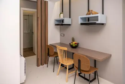 a dining room with a wooden table and chairs at Disegno Residences in Chania Town