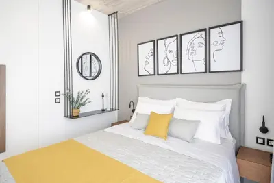 a bedroom with a bed with white and yellow pillows at Disegno Residences in Chania Town