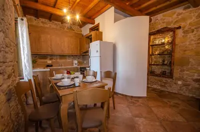 a kitchen with a table with chairs and a refrigerator at Metochi Traditional House in Chania Town