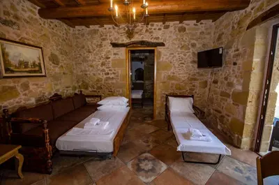a room with two beds and a tv in it at Metochi Traditional House in Chania Town