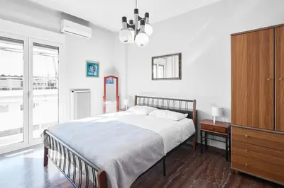 a white bedroom with a bed and a dresser at Angelina House in Chania Town