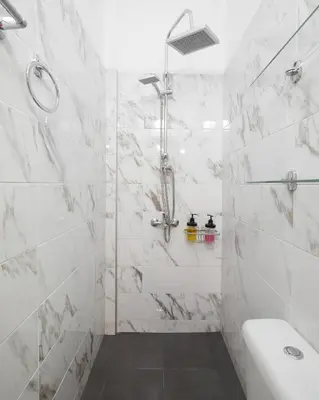 a white bathroom with a shower and a sink at Angelina House in Chania Town