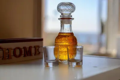 a bottle of honey and two glasses on a table at The Botanist Rooms, Ritzou in Chania Town