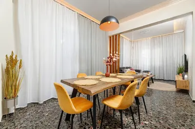a dining room with a table and yellow chairs at Dk central apartment in the heart of the city in Chania Town