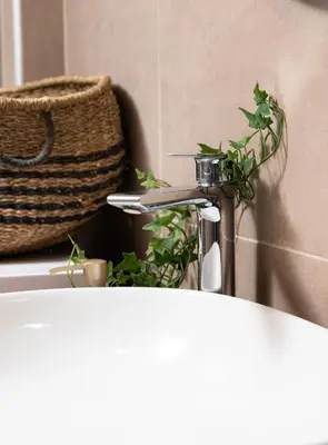 a bathroom sink with a faucet and a basket at Dk central apartment in the heart of the city in Chania Town