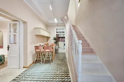 a hallway with stairs and a table with stools at Elyn House in Chania Town
