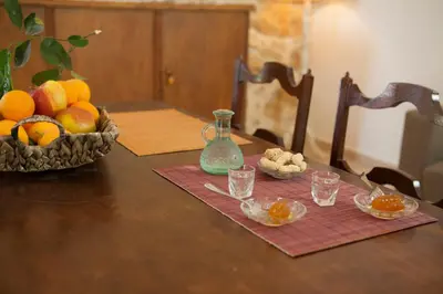 a table with a bowl of fruit and a bowl of nuts at Cretan cottage of 1900 with beautiful olive yard in Kissamos