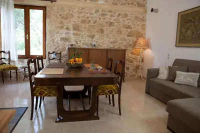 a living room with a table and a couch at Cretan cottage of 1900 with beautiful olive yard in Kissamos