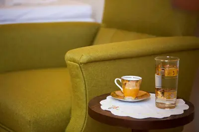 a cup of tea on a table next to a couch at Cretan cottage of 1900 with beautiful olive yard in Kissamos