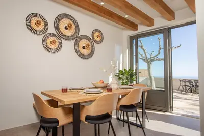 a dining room with a wooden table and chairs at Elirion Luxury Home in Kamária