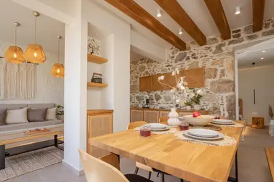 a kitchen and dining room with a wooden table at Elirion Luxury Home in Kamária