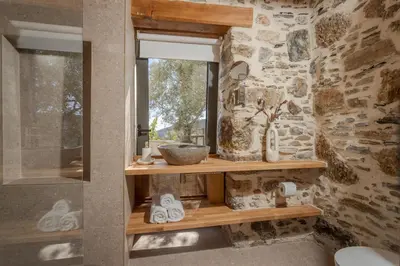 a bathroom with a window and a shelf with towels at Elirion Luxury Home in Kamária