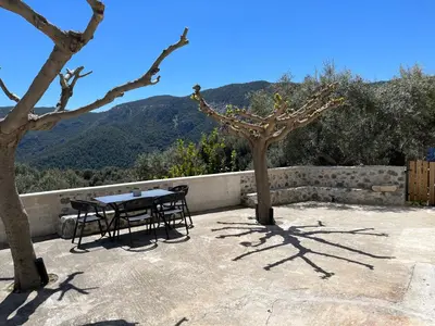 a table and chairs on a patio with mountains in the background at Elirion Luxury Home in Kamária