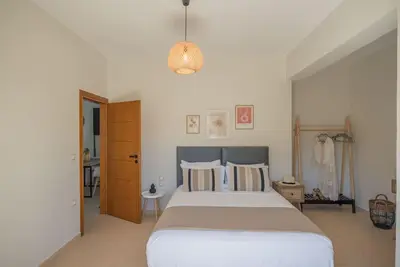 a bedroom with a large bed and a pendant light at Summer Blue Apartments Chania in Chania Town