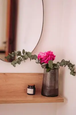 a vase with a pink rose in front of a mirror at Summer Blue Apartments Chania in Chania Town