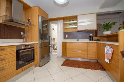 a kitchen with wooden cabinets and stainless steel appliances at Jasmine House Kissamos in Kissamos